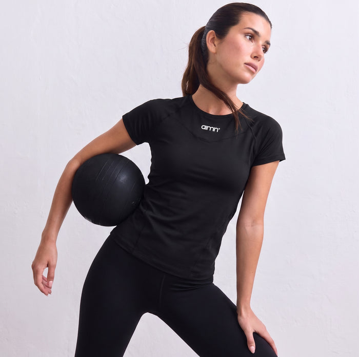 Black aim'n Soft Basic short-sleeved top styled with matching leggings and white sneakers.