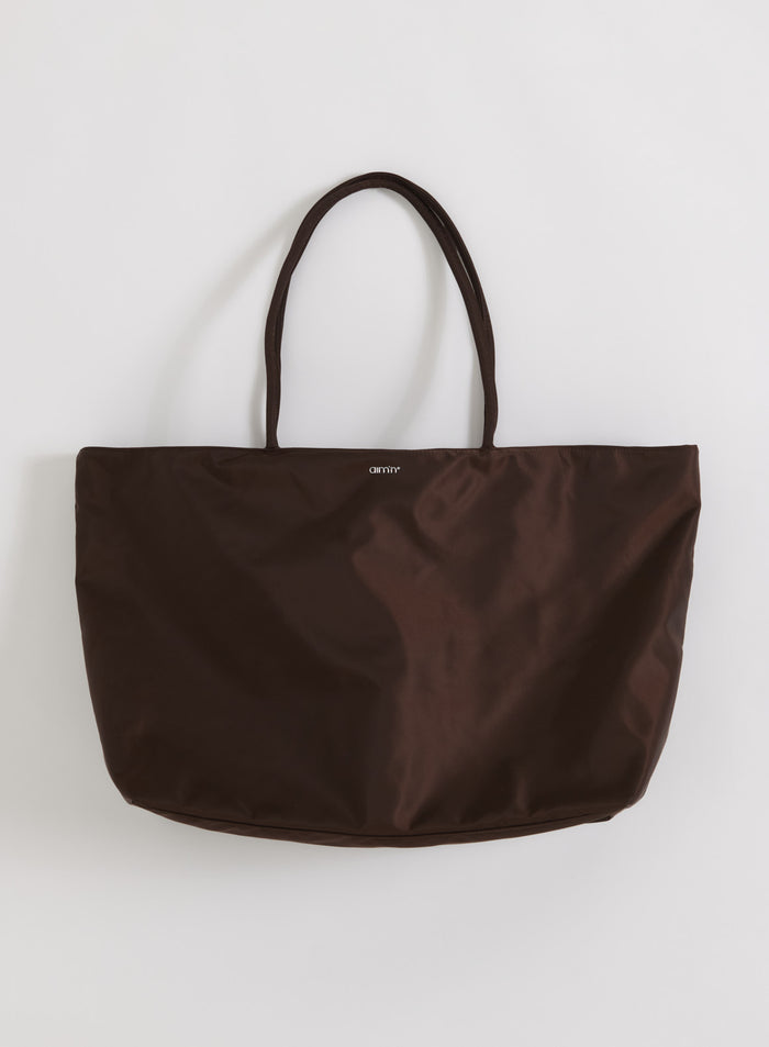 Spacious chocolate brown nylon weekend bag by aim'n featuring slim handles and a minimalist logo.