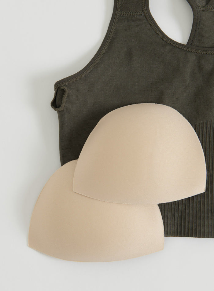 Close-up flat lay of a dark ivy ribbed seamless high-support sports bra with removable pads