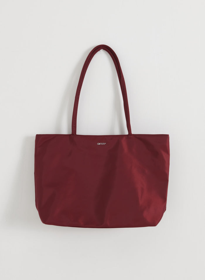 Merlot Nylon Tote Bag from aim'n with long shoulder straps and a small front logo on a white background.