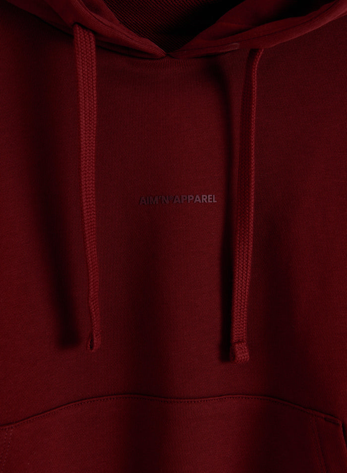 Ruby red chunky cotton terry hoodie featuring a drawstring and tonal aim'n logo.