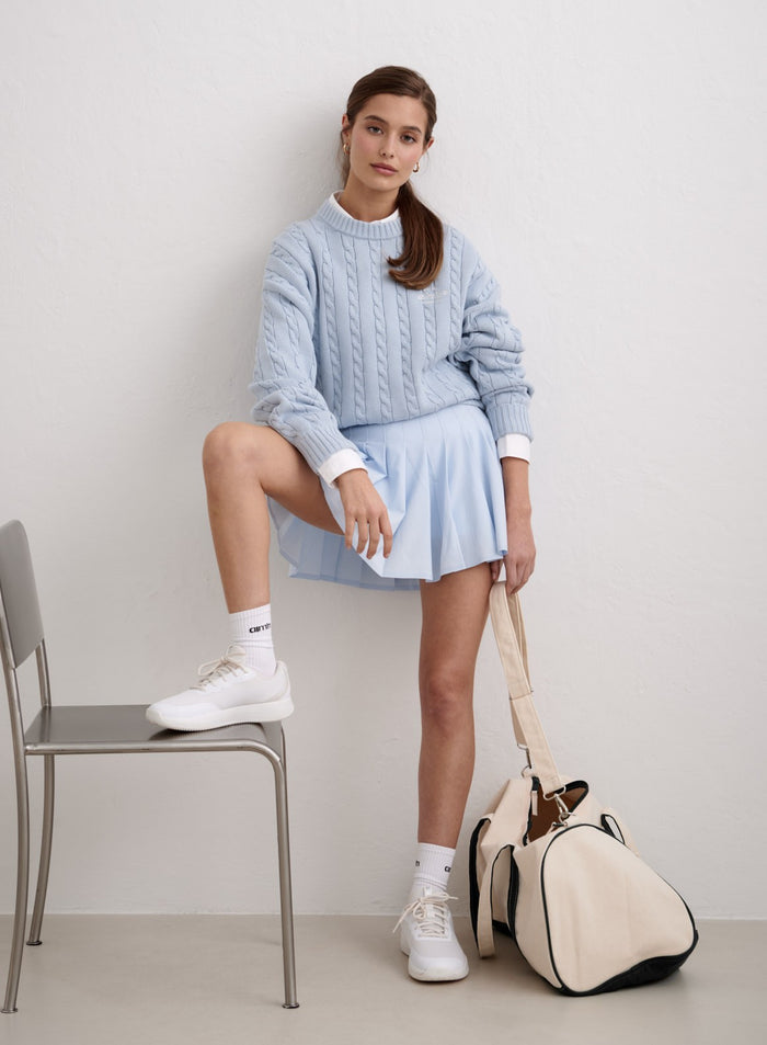 Aura blue cotton cable knit sweater styled with a matching pleated skirt and white sneakers [M-174cm]