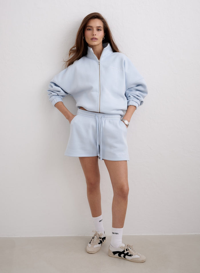 Woman wearing light blue Aura Script Sweat Shorts and a zip-up hoodie by aim'n [S-174cm]