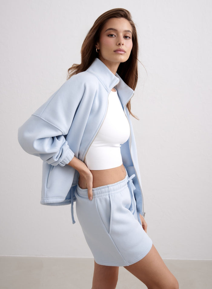 Light blue Aura Script Sweat Shorts styled with a matching zip jacket and white tank top. [S-174cm]