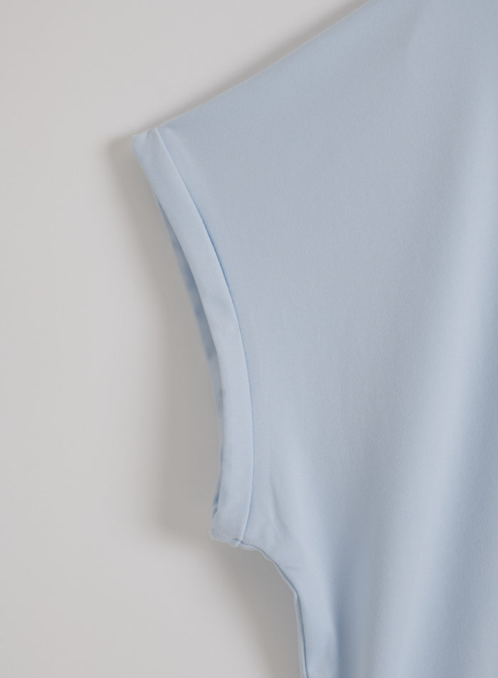 Rolled sleeve hem detail on an aura blue aim'n Soft Basic Roll Sleeve Top in a flatlay view.