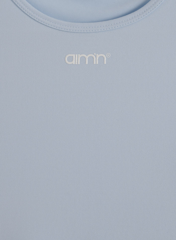 Light blue Soft Basic Singlet featuring a round neckline and white printed aim'n logo on soft material.