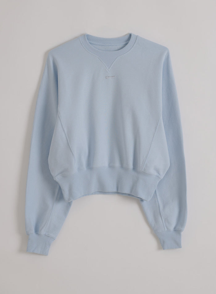 Light blue Aura Sportif Sweatshirt with piqué texture, ribbed trims, and a subtle aim'n logo in a clean flatlay.