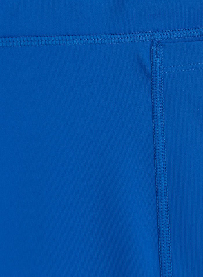 Close-up of the azure blue fabric and flatlock seams on these aim'n Running Midi Biker Shorts.