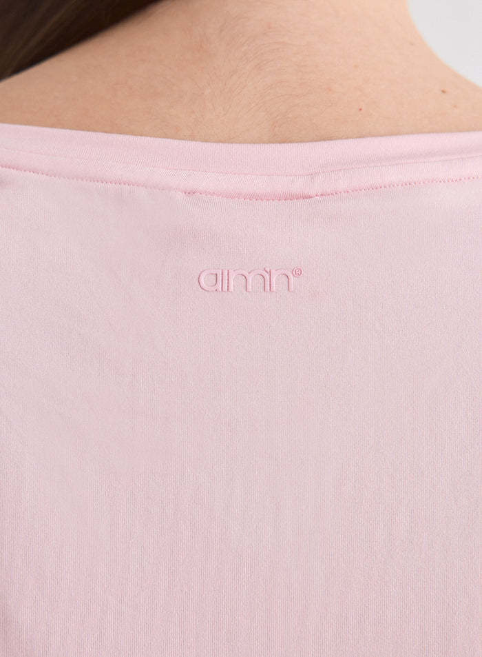 Close-up of the tonal aim'n logo on the back of the Ballerina Soft Basic Roll Sleeve Top [L-174cm]