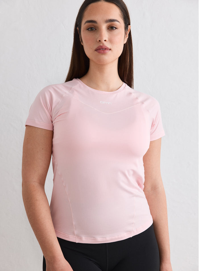 A woman wearing a light pink Ballerina Soft Basic Short Sleeve training top by aim'n [L-174cm]