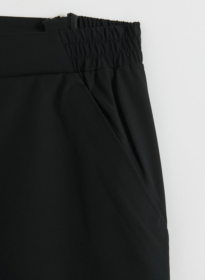 Close-up of black 3L shell pants showing the elastic waistband and side pocket