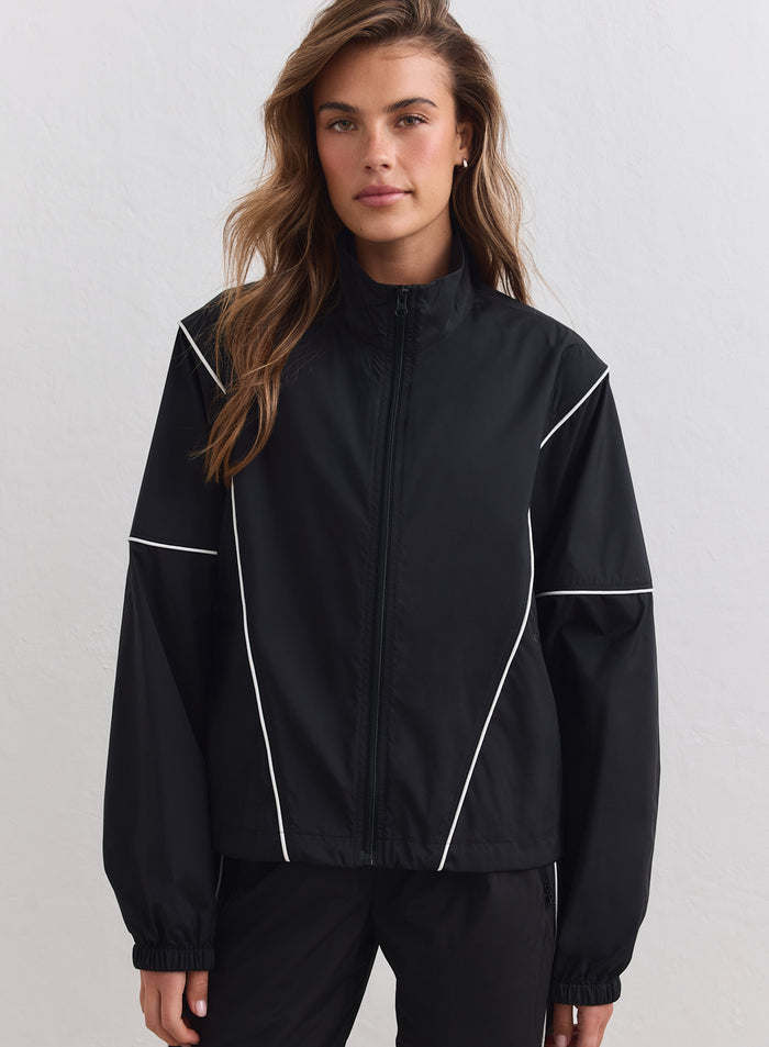 Black aim'n Balance Windstopper Tracksuit Jacket featuring white contrast piping and a zip-up high collar.