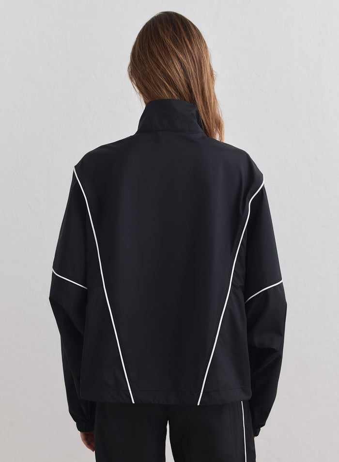 Rear view of the black Balance Windstopper Tracksuit Jacket with white piping by aim'n.