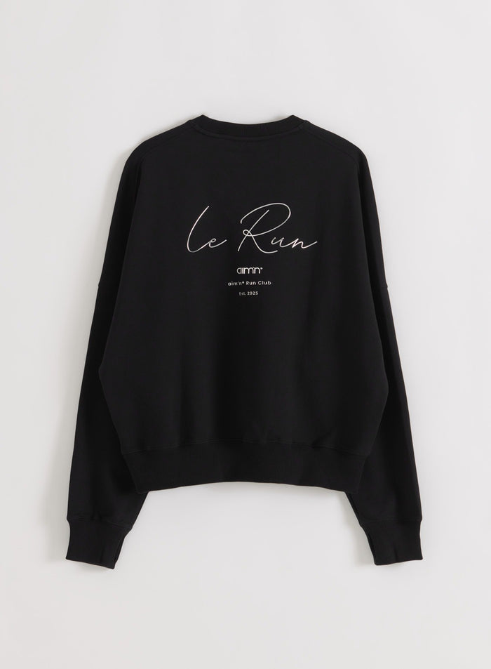 Black Le Run Running Sweatshirt seen from the back in flatlay showing the white Le Run back artwork