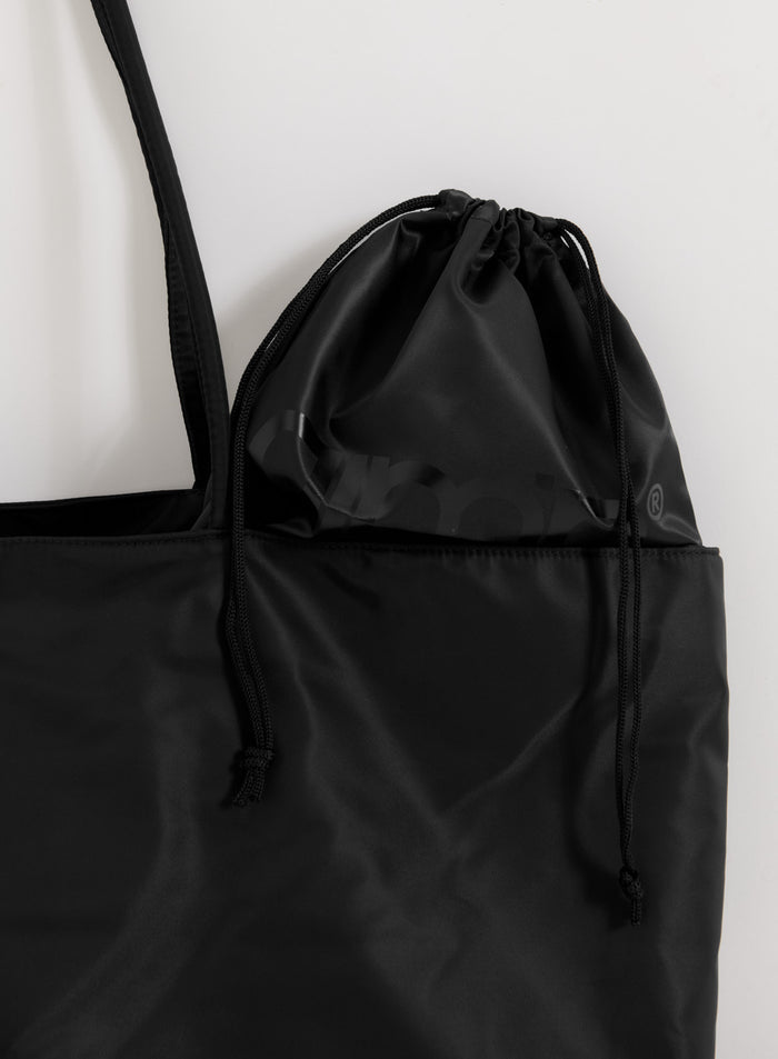 Black nylon weekend bag with a matching drawstring pouch featuring a tonal aim'n logo.