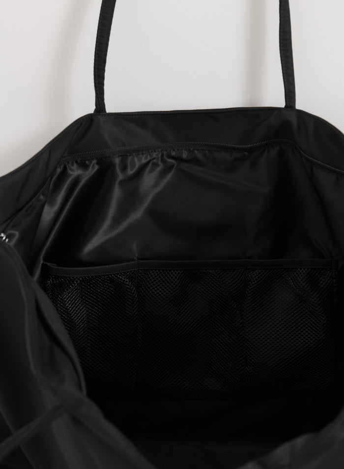 Black aim'n Nylon Weekend Bag interior featuring a smooth lining and internal mesh pocket.