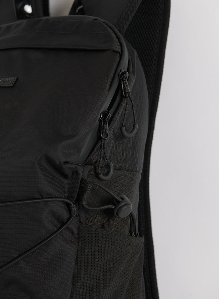Close-up of the zipper and side pocket details on the black Outdoor Daypack