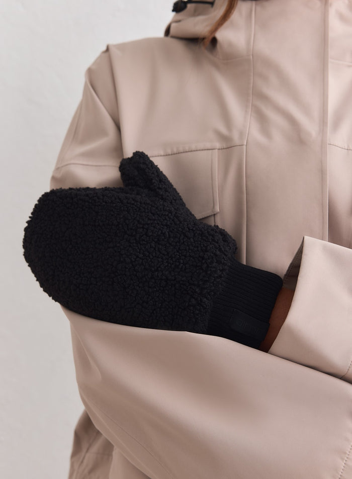 Textured black pile mittens by aim'n featuring ribbed cuffs, styled with a beige outdoor jacket.