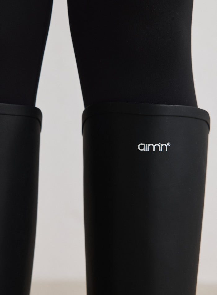 Close-up of the black rain boots featuring the white aim'n logo