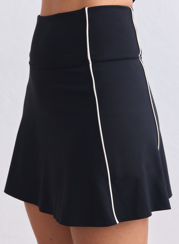 High-waisted black Sense Contrast Skort with white piping and a discreet aim'n logo. [XS-165cm]