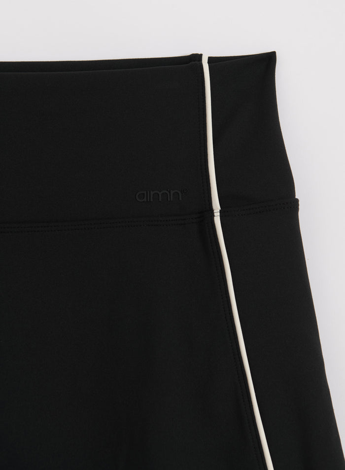 Black aim'n Sense Contrast Skort featuring white contrast piping and a subtle embossed logo.