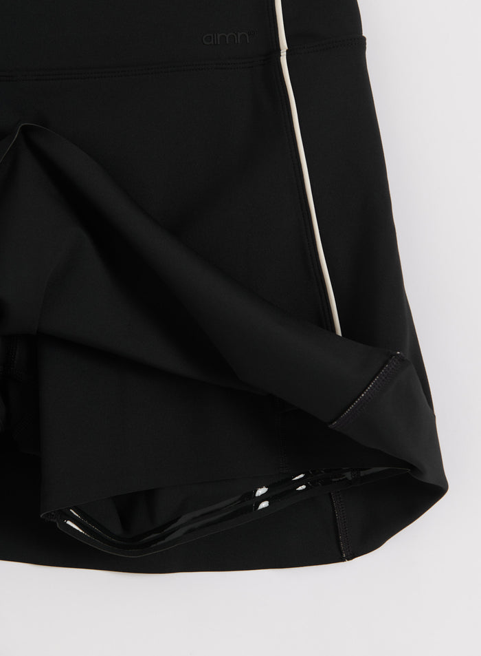 Black Sense Contrast Skort with white piping detail and aim'n logo in a close-up flatlay view.