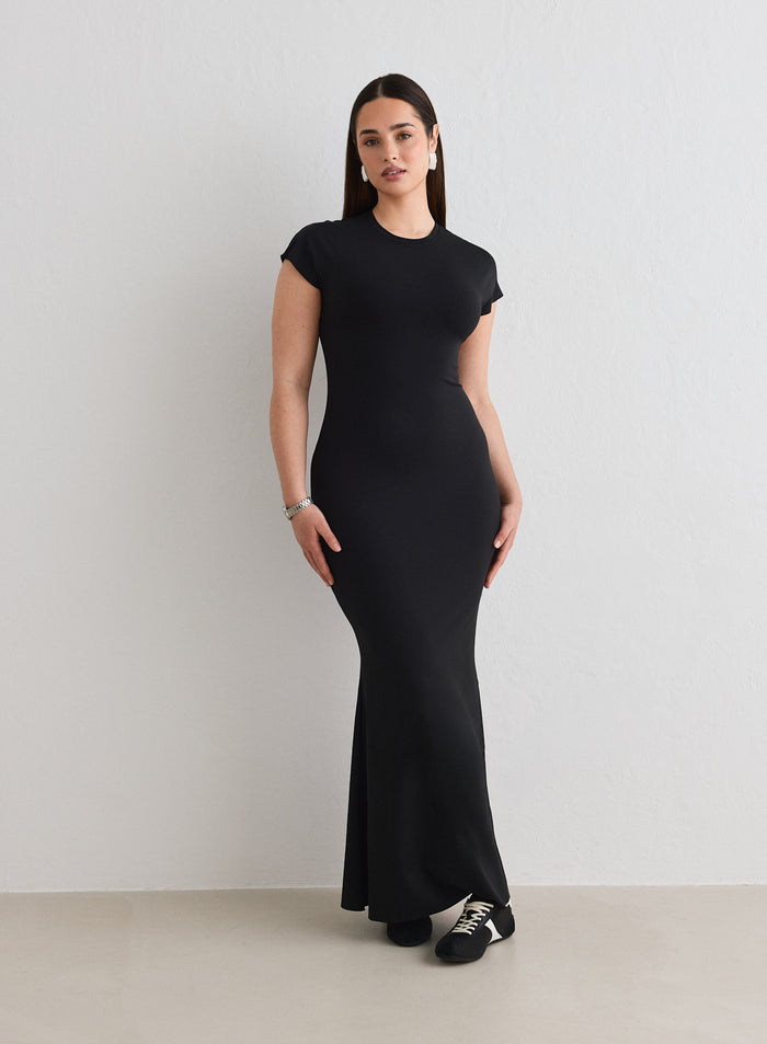 A woman wearing a black Sense Mermaid Cap Sleeve Dress from aim'n [L-174cm]