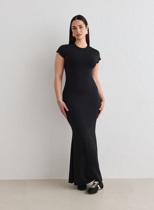A woman wearing a black Sense Mermaid Cap Sleeve Dress from aim'n [L-174cm]