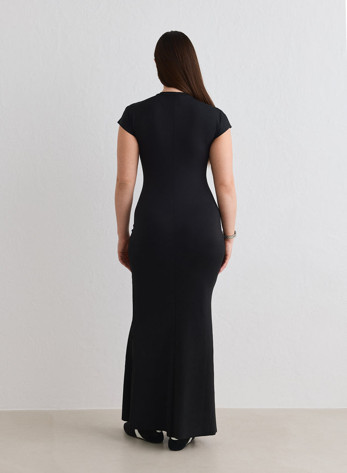 Rear view of a model wearing the Black Sense Mermaid Cap Sleeve Dress from aim'n [L-174cm]