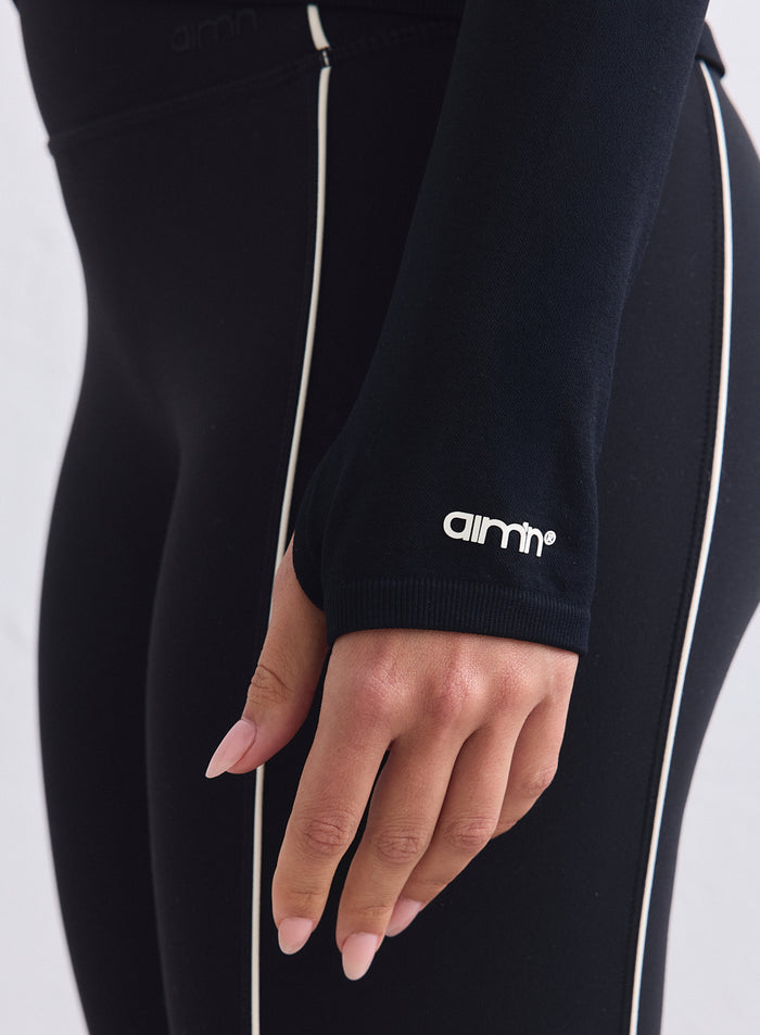 Black seamless jacket sleeve with white contrast piping and aim'n logo on the ribbed cuff. [XS-165cm]