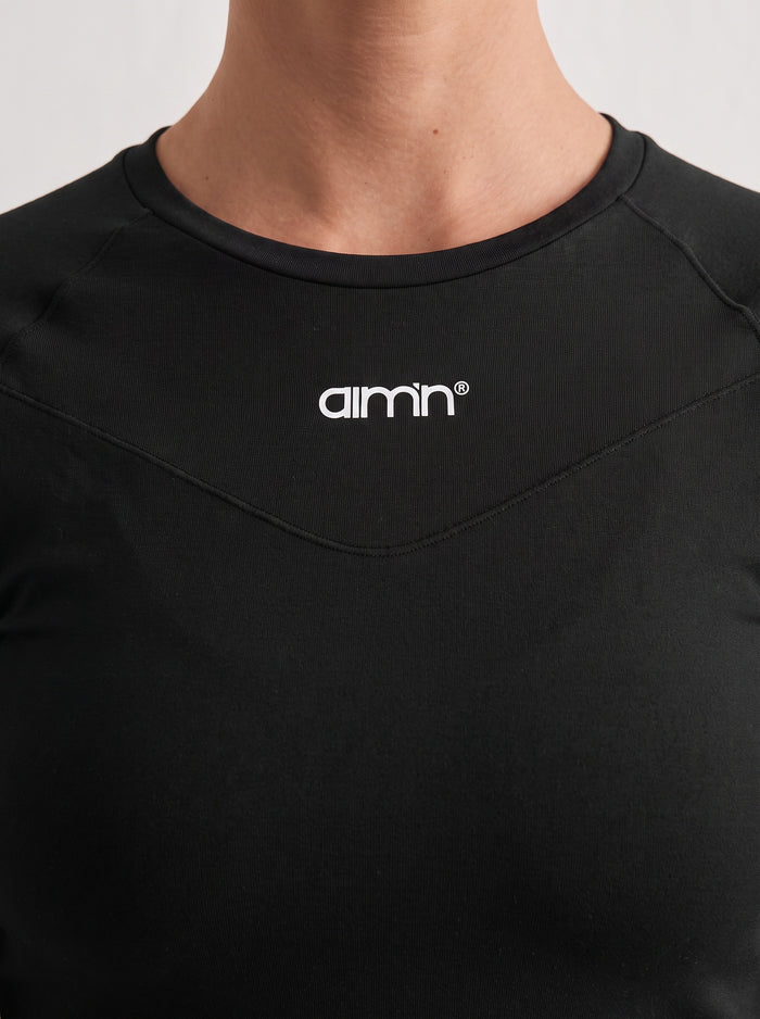 Back view of the black Soft Basic Long Sleeve from aim'n, featuring raglan sleeves and a form-fitting second skin feel.