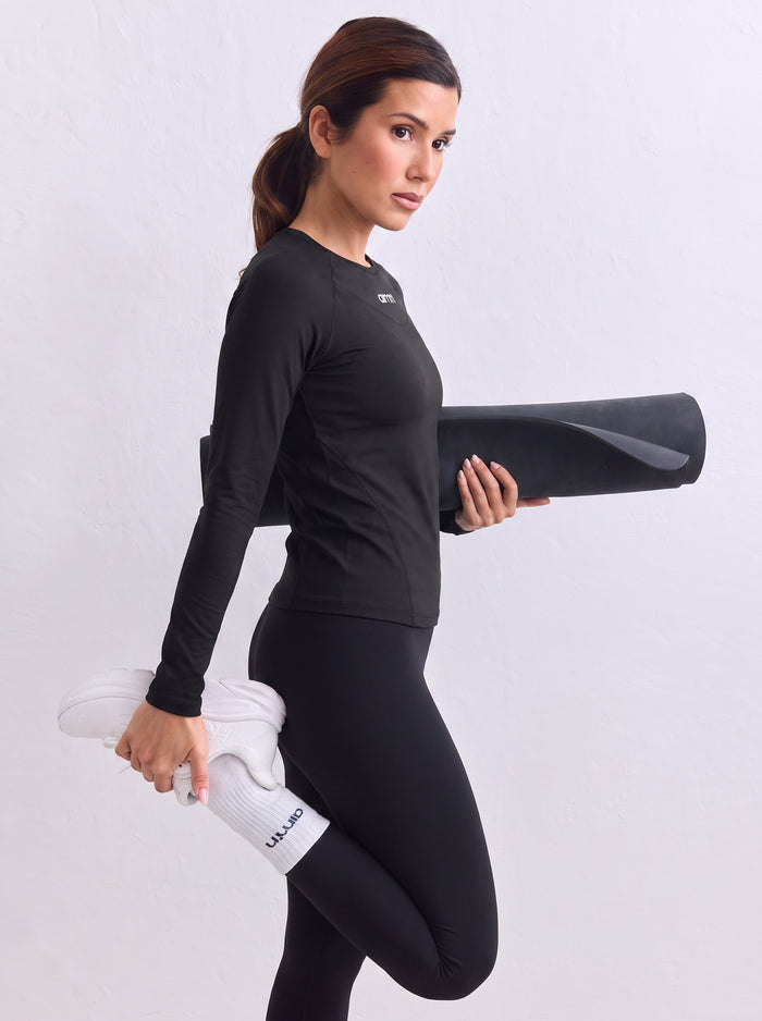 Black aim'n Soft Basic Long Sleeve with a second skin feel, paired with matching leggings and white sneakers.