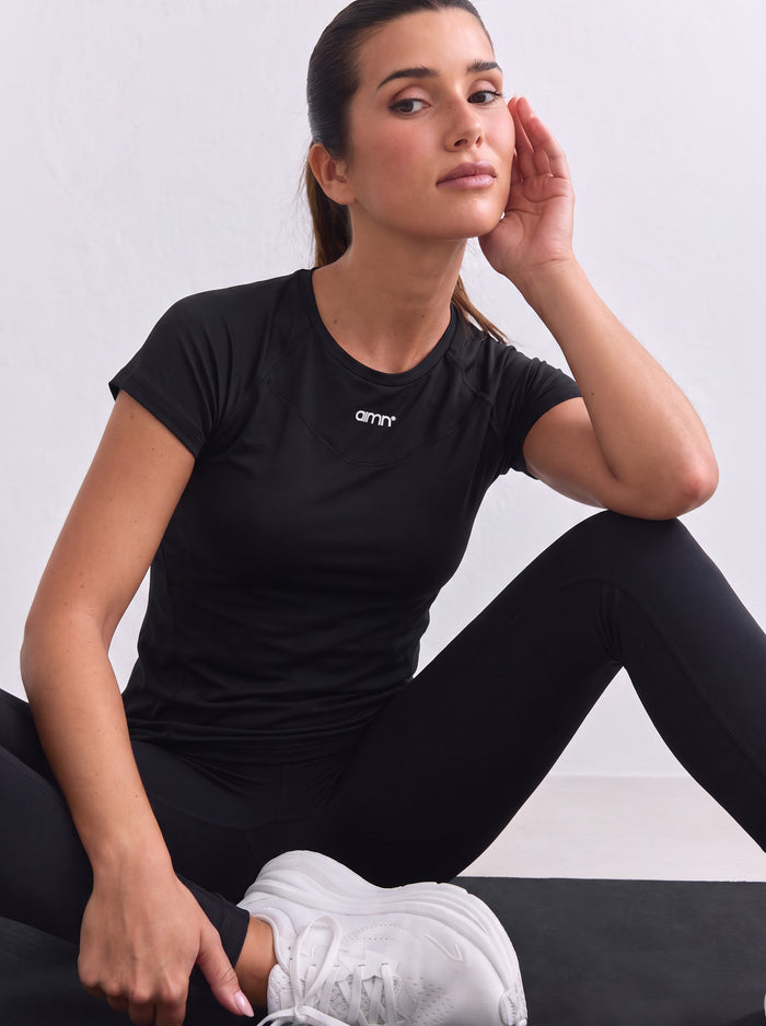 Black aim'n Soft Basic Short Sleeve top with raglan sleeves and a white logo on the neckline.