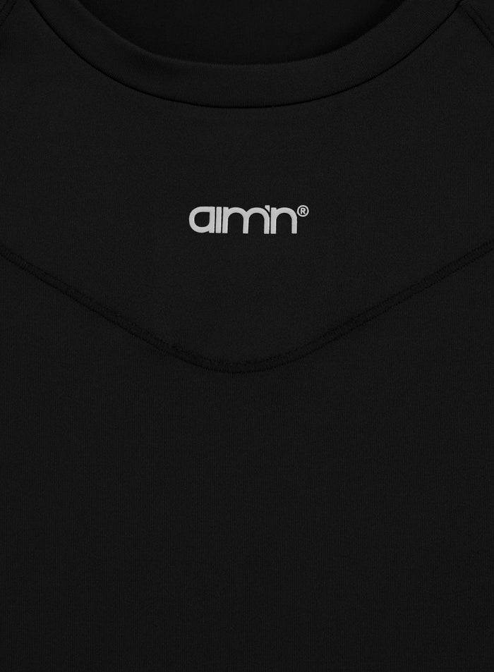 Black Soft Basic Short Sleeve top with a white aim'n logo and feminine V-shaped pintuck seam detail.
