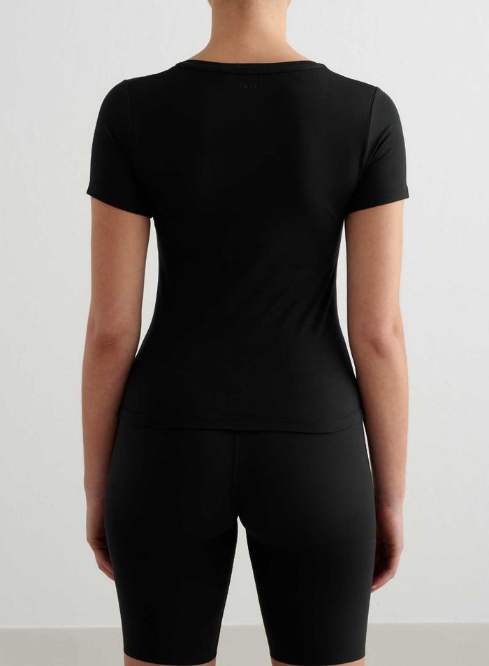 Black tight-fit short-sleeved training top in ultra-soft functional fabric, back view by aim'n.
