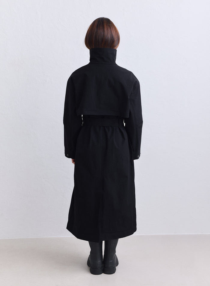 Long black aim'n waterproof coat with a high collar and storm flap viewed from behind [S-165cm]