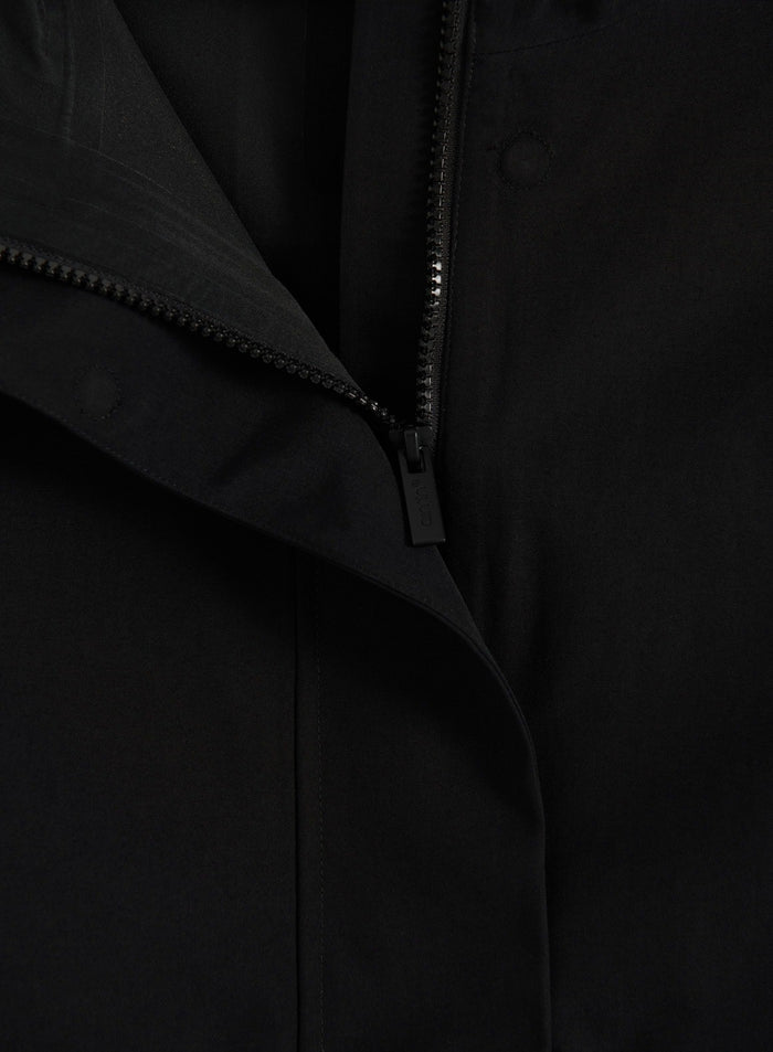 Close-up of the zipper and storm placket on the black aim'n Waterproof Hood Jacket