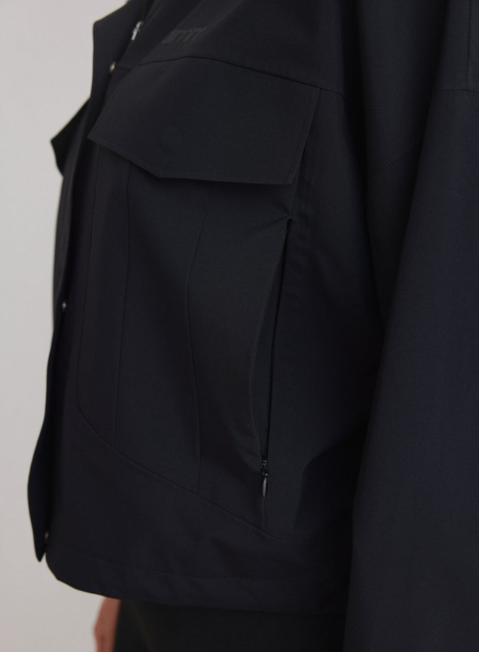 Close-up of the black Waterproof Jacket showing cargo and zip pocket details [M-174cm]