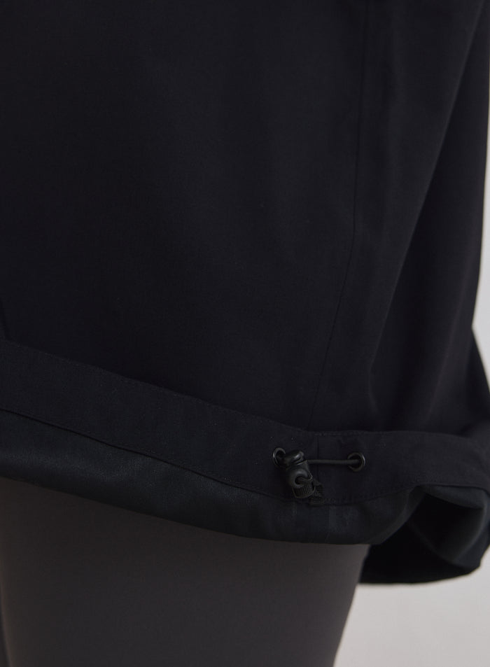 Close-up detail of the adjustable bottom hem with drawstring on the Black Waterproof Oversized Anorak [M-174cm]
