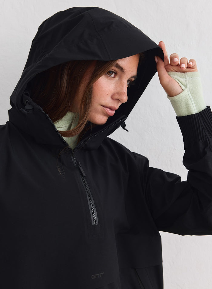 Black Waterproof Stretch Anorak featuring a protective hood and half-zip detail by aim'n. [xs-178cm]