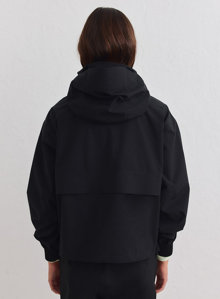 Black aim'n Waterproof Stretch Anorak featuring a functional hood and back vent detail. [xs-178cm]