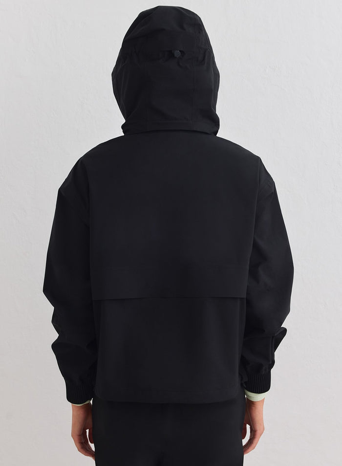 Black waterproof stretch anorak from aim'n with a hood and back vent. [xs-178cm]