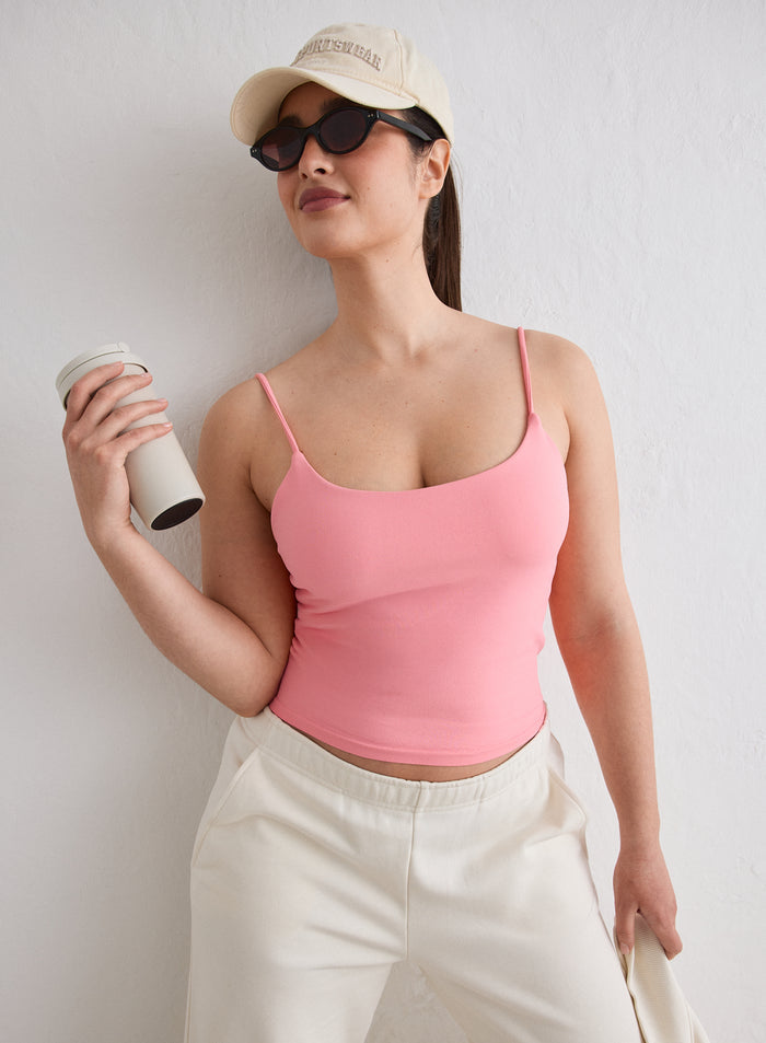 A model wearing a Blush Shape Seamless Strap Singlet, beige trousers and a cap [L-174cm]