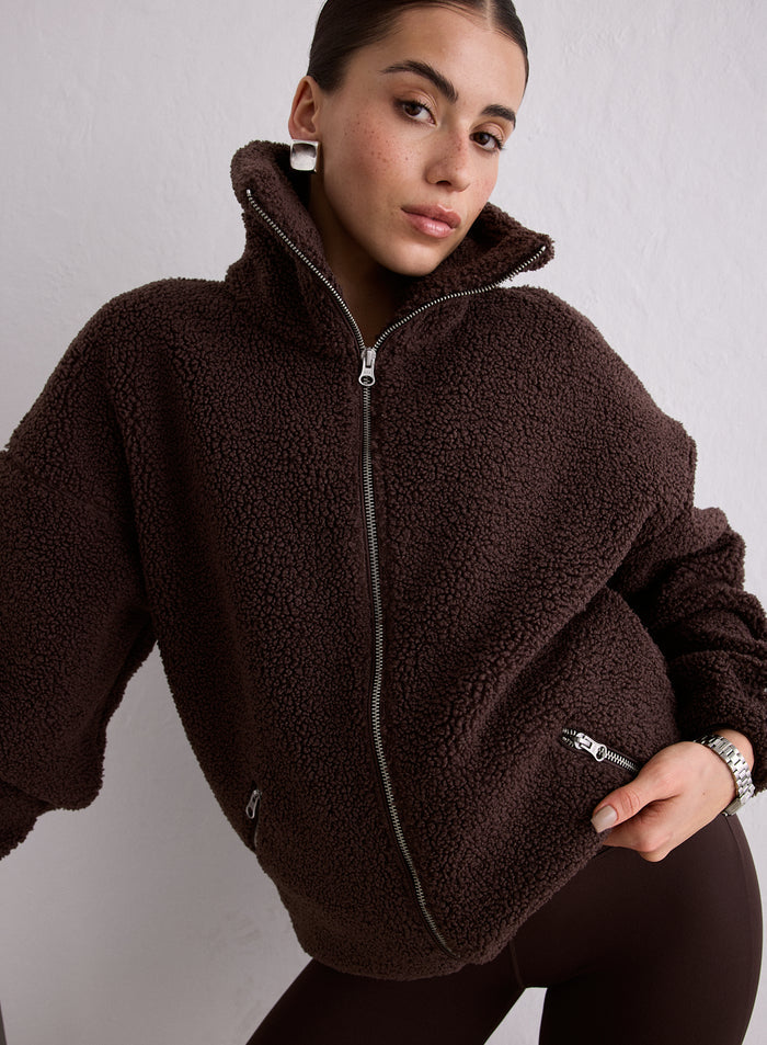 A woman wearing a brown Cacao Pile Jacket with a high collar and front zipper [M-174cm]