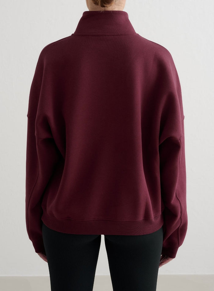 Cherry red aim'n Varsity Sweat Half Zip sweatshirt shown from the back, featuring a relaxed fit and dropped shoulders.