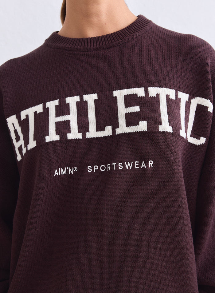 Close-up of a chocolate brown Athletic Knit Sweatshirt by aim'n with white logo detail [S-165cm]