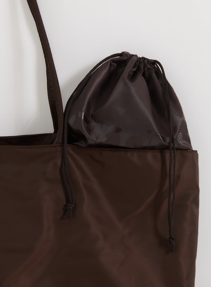 Chocolate brown nylon weekend bag featuring a matching drawstring pouch with a tonal aim'n logo