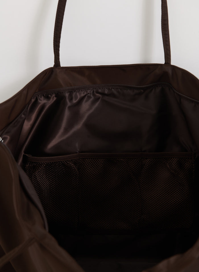 Interior of the chocolate brown nylon weekend bag by aim'n featuring a mesh pocket and smooth lining.