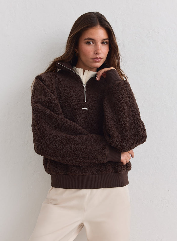 Chocolate brown Pile Half Zip fleece with a textured finish and ribbed cuffs by aim'n, styled with beige pants. [xs-178cm]