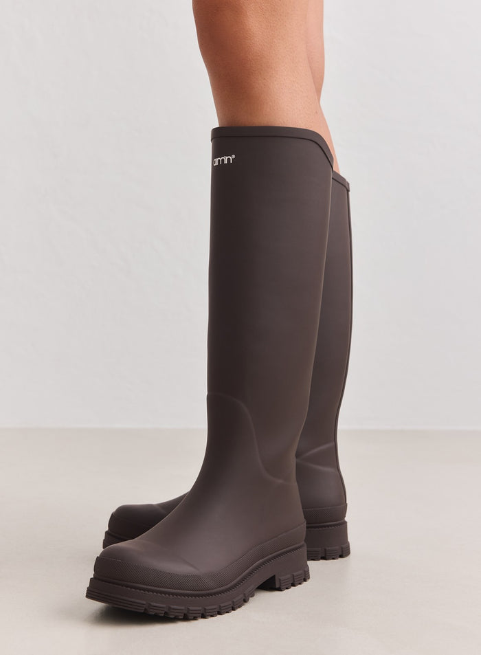 Knee-high chocolate rain boots by aim'n with a matte rubber finish and durable chunky treaded outsoles.